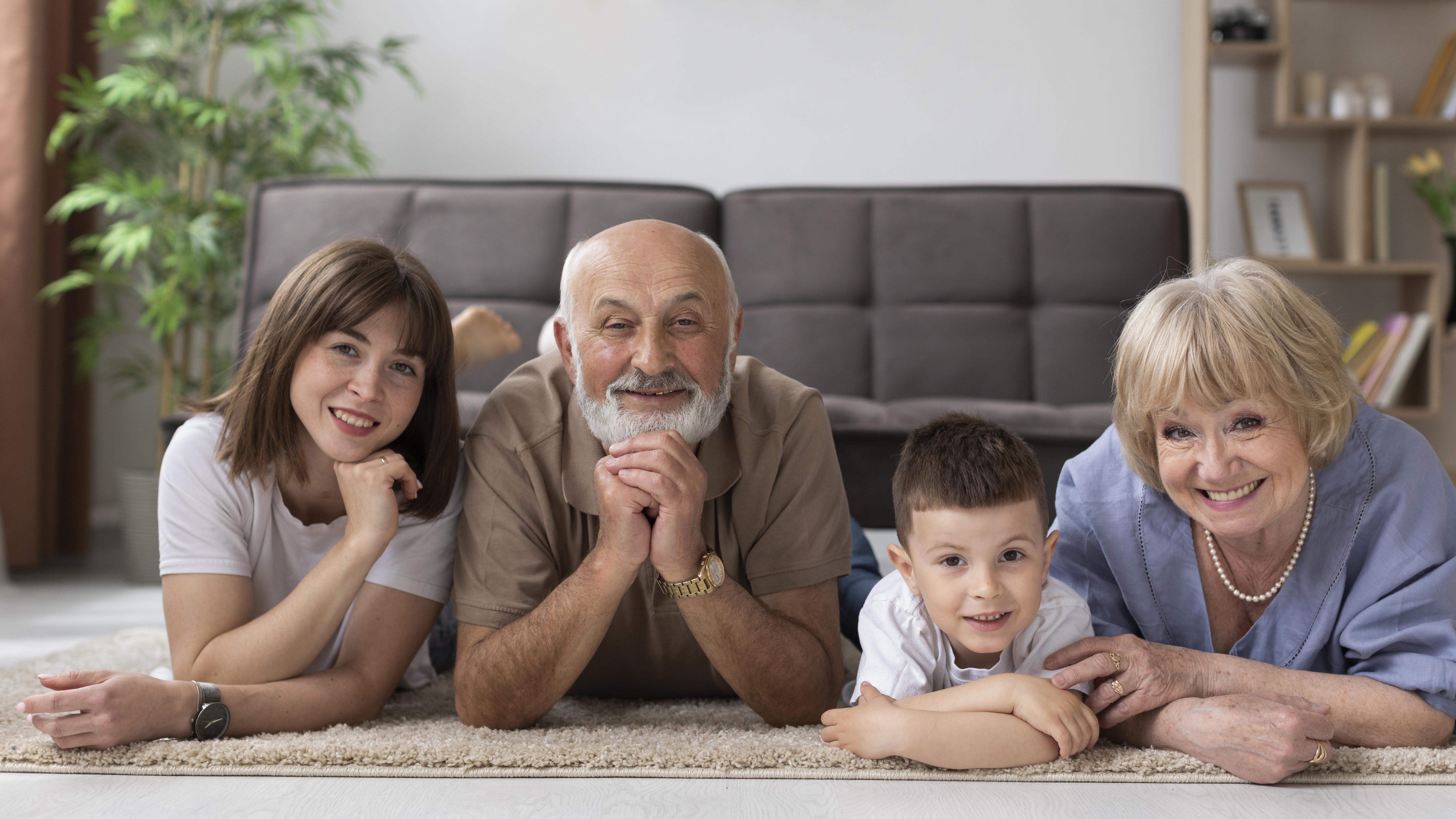 Elderly couple laying on the ground with their family